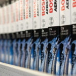 Verschiedene Scheibenwischer der Firma Bosch stehen in einem Regal.